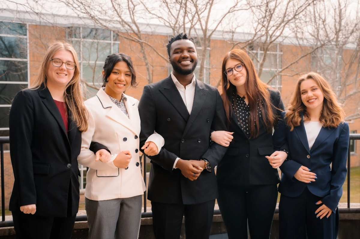 five students standing with arms interlinked